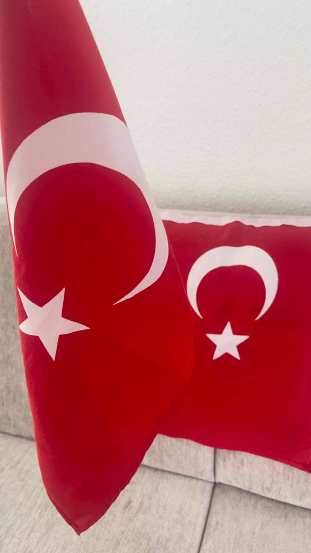 Zwei getestete Türkei-Flaggen, während eine über der Lehne eines Sofas liegt und die aufrecht präsentiert wird.