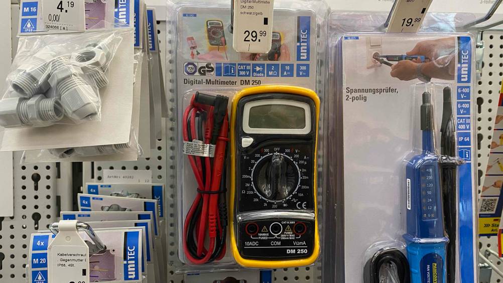 Ein getestetes Multimeter in seiner Verpackung hängt im Regal.