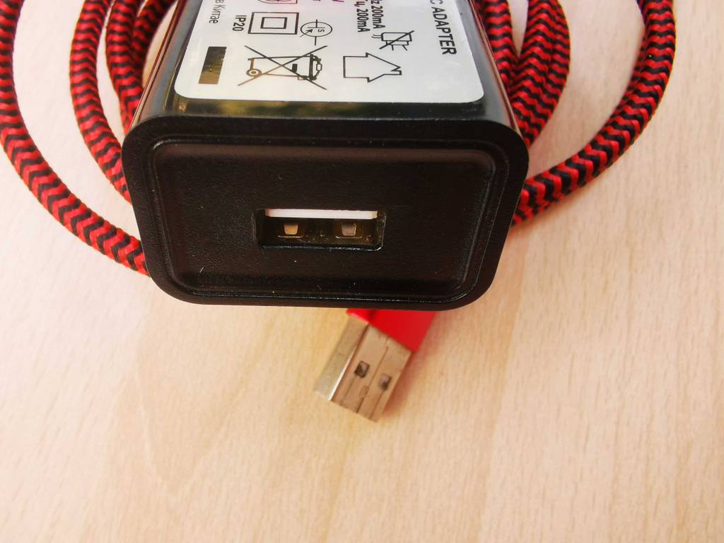 Das getestete USB-Ladegerät mit dem Fokus, der auf der USB-Buchse und dem USB-Kabel liegt.