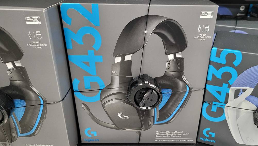 Ein Originalkarton des getesteten 7.1-Headsets von vorne in einem Regal neben anderen Produkten.