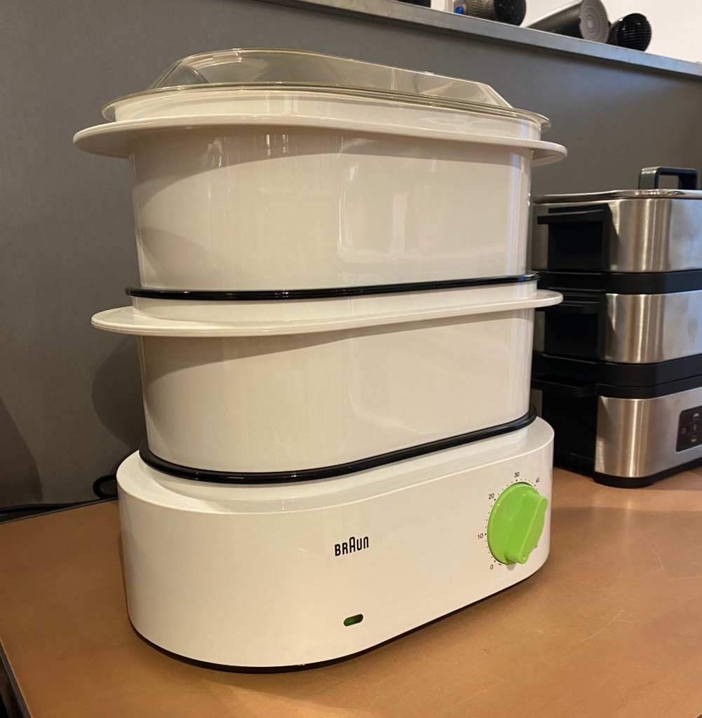 Dampfgarer getestet: weißer Dampfgarer von Braun mit grünem Drehregler steht in einem Regal.