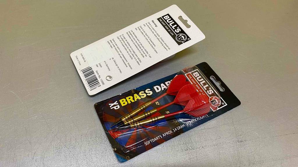 Im Test: Zwei Packungen Softdarts liegen nebeneinander auf einem grauen Boden.