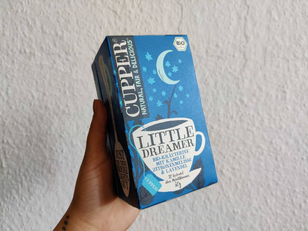 Schlaftee getestet: eine Packung Schlaftee von Cupper wird in der Hand vor einer weißen Wand gehalten.