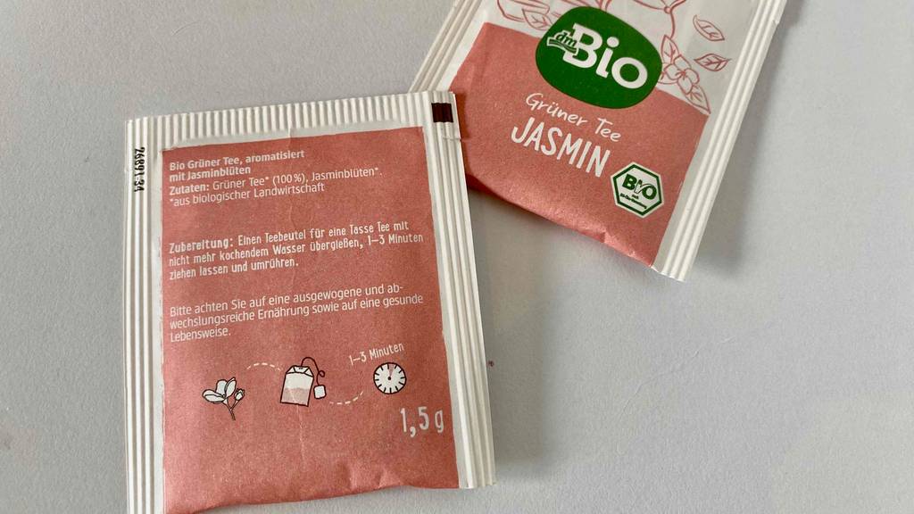 Jasmintee im Test: Zwei verpackte Jasminteebeutel auf einer weißen Oberfläche liegend.