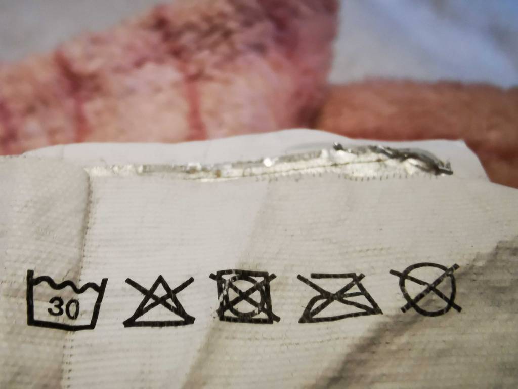 Nahaufnahme des Etiketts mit den Pflegehinweisen der getesteten Fleecedecke.
