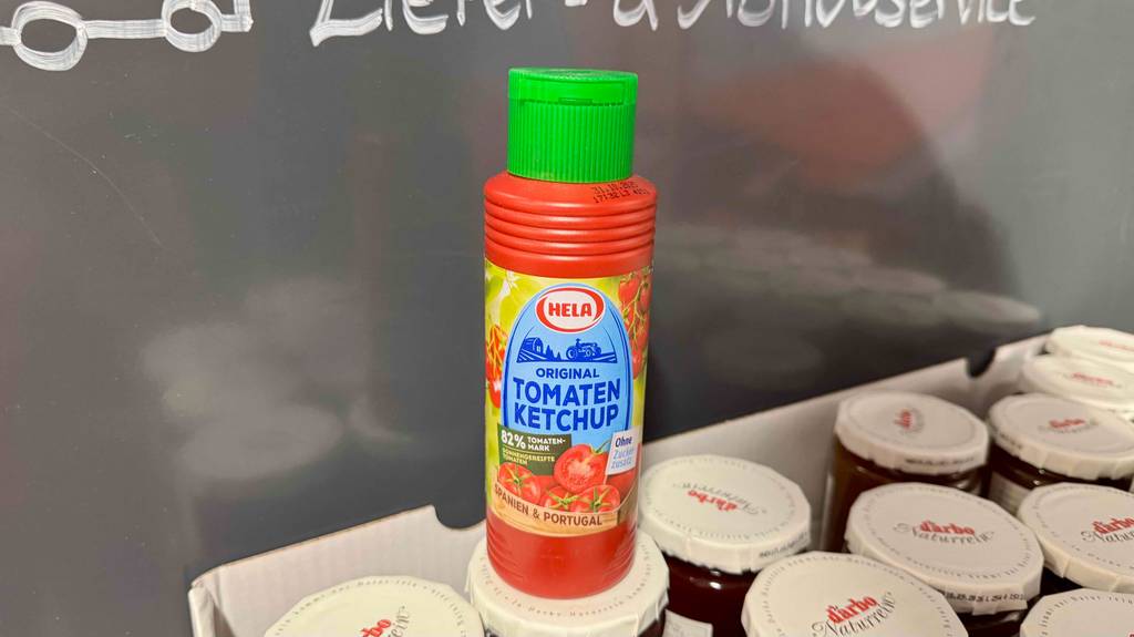 Ein getestetes Hela-Ketchup steht auf einem offenen Karton, der mit Darbo Marmelade gefüllt ist.