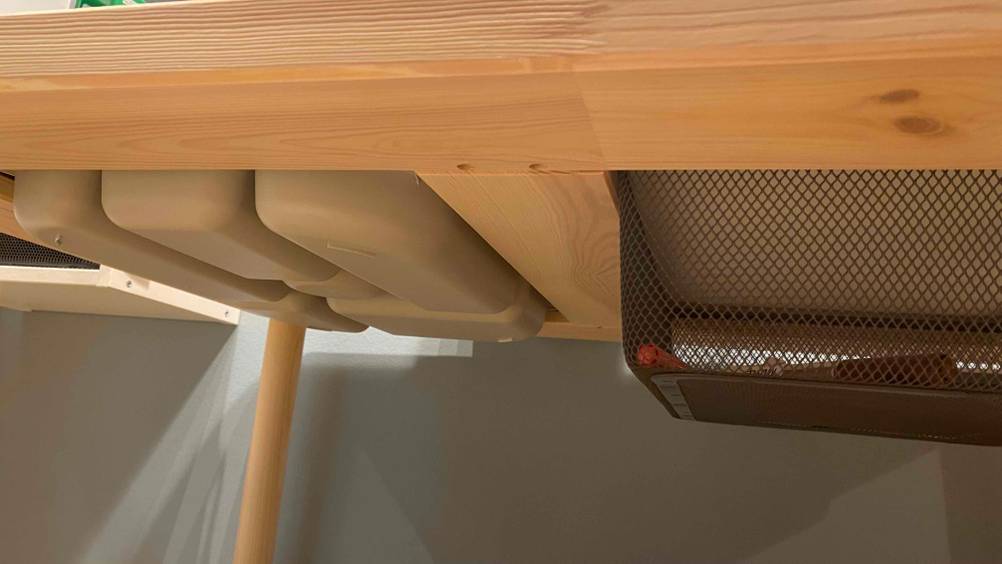 Kindertisch-Test: Ein Kindertisch von unten mit einem Korb ersichtlich.