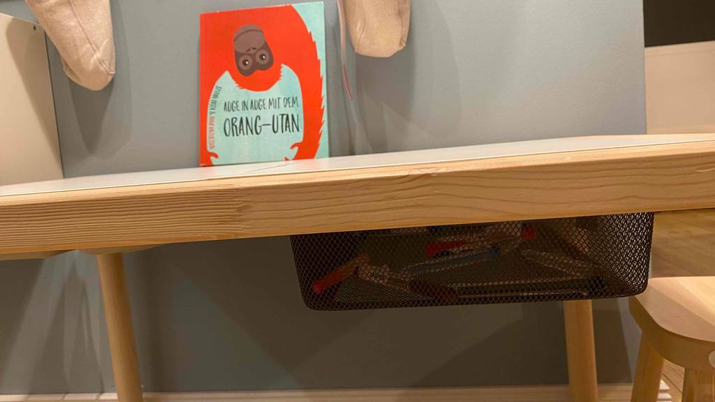 Getesteter Kindertisch von der Seite mit Körben zu sehen.