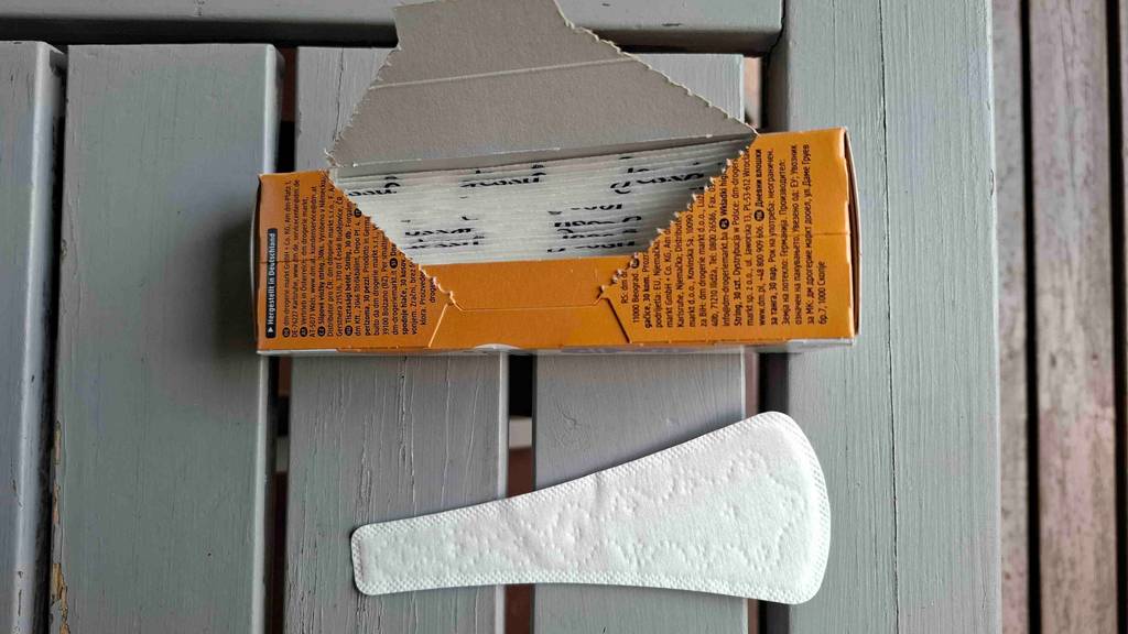 Eine Slipeinlage für Tangas im Test liegt neben der geöffneten orangefarbenen Verpackung.