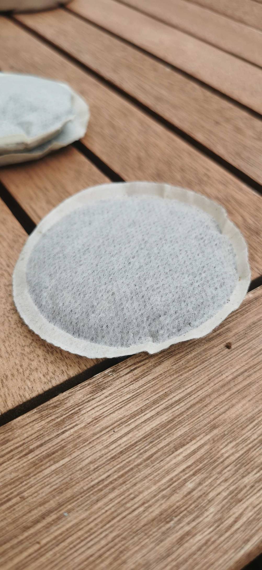 Nahaufnahme eines getesteten Kaffeepads auf einem Holztisch.