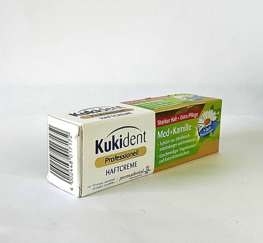 Die Haftcreme im Test befindet sich in der Tube innerhalb einer Verpackung von Kukident auf einer weißen Oberfläche.