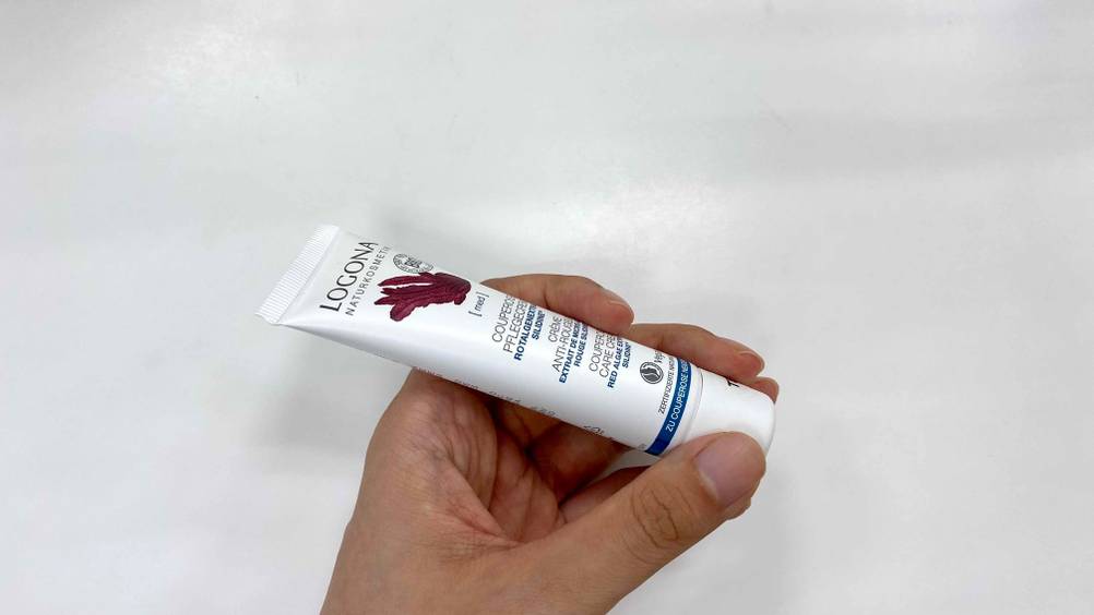 Couperose-Creme getestet: eine Tube Couperose-Creme wird in der Hand vor einer weißen Wand gehalten.