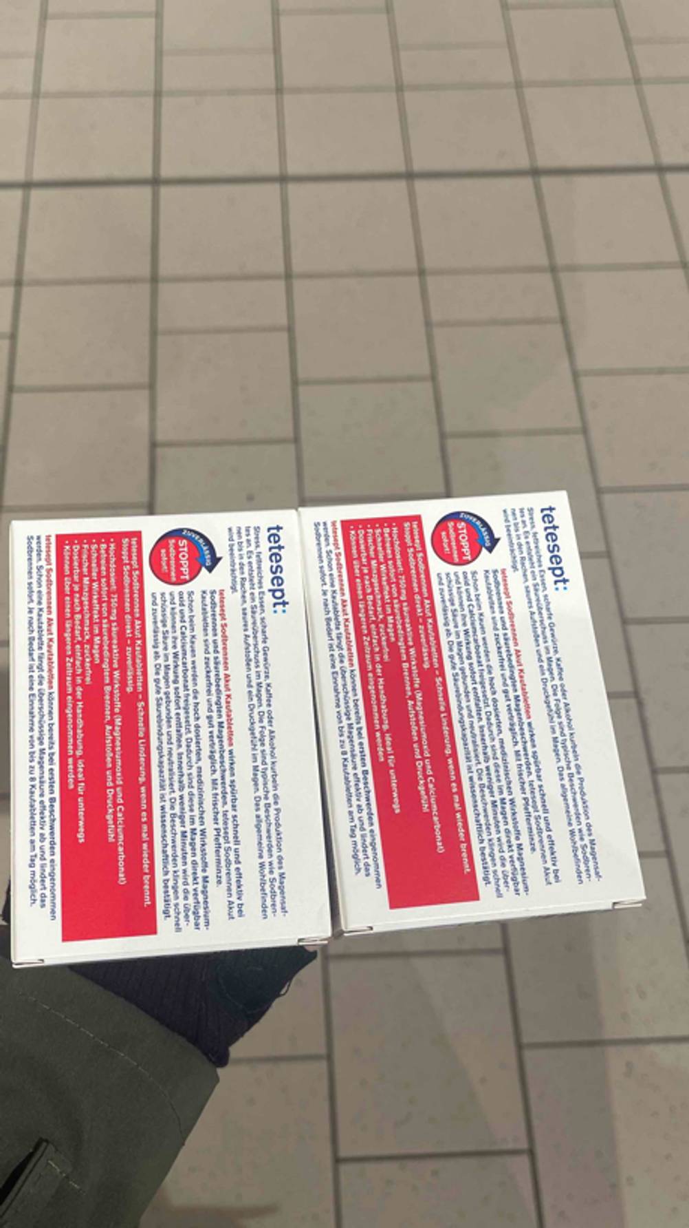 Zwei Verpackungen werden in der Hand gehalten, worin sich das getestete Mittel gegen Sodbrennen befindet.