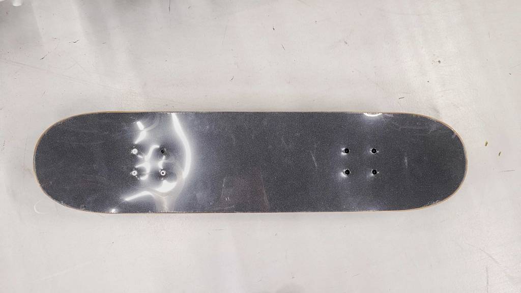 Im Test: Ein Skateboard von oben auf einem grauen Boden.