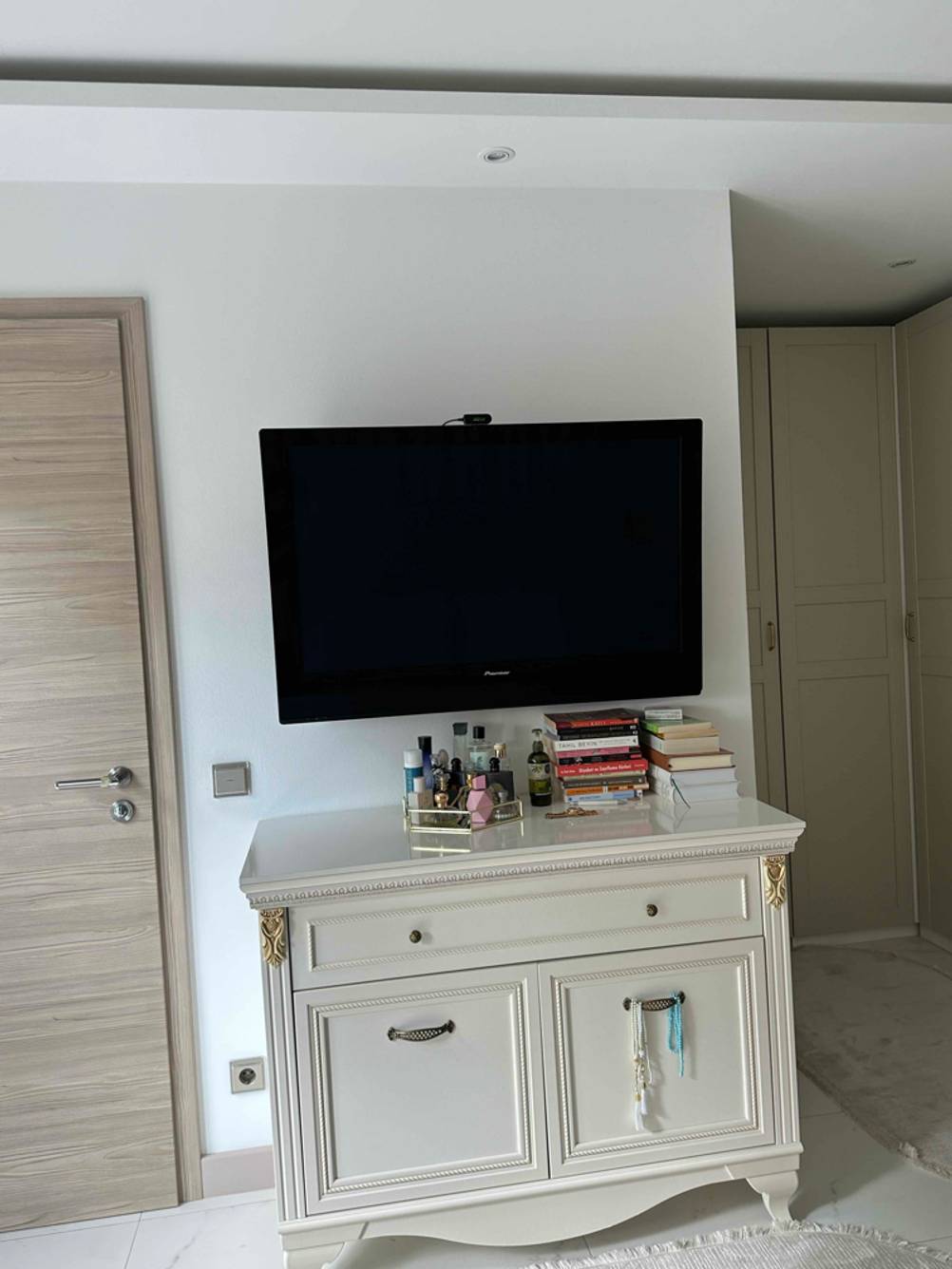 Ein getesteter 49-Zoll-Fernseher hängt auf einer Wand ober einer Kommode.