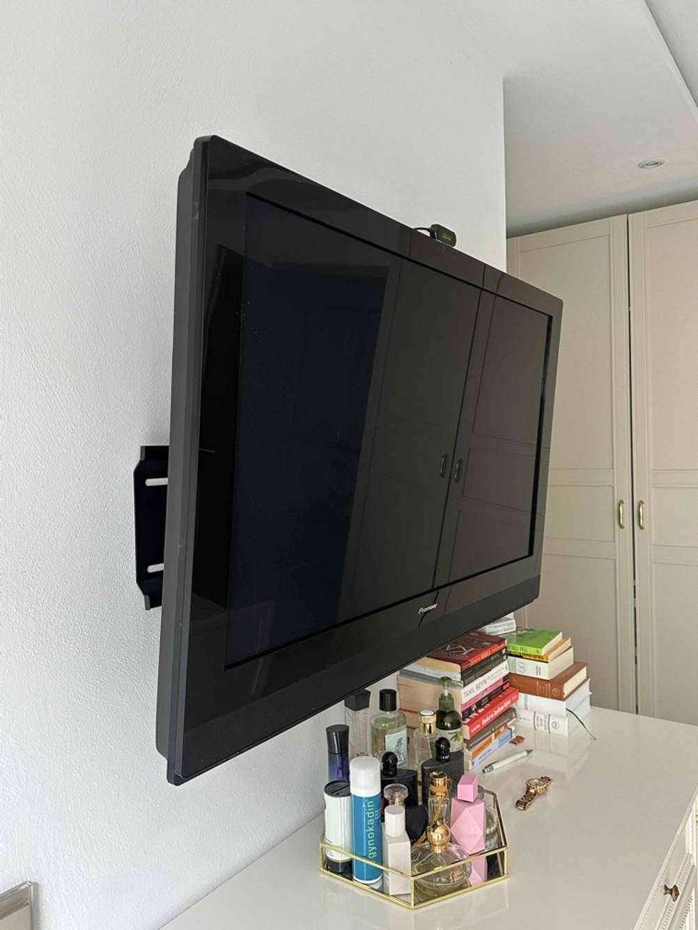 Ein getesteter kleiner Fernseher hängt auf einer weißen Wand.