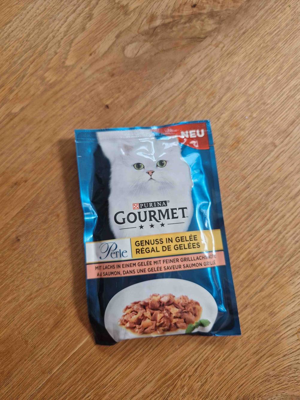 Eine Packung des getesteten Katzenfutter von Purina liegt auf einer Holzfläche.