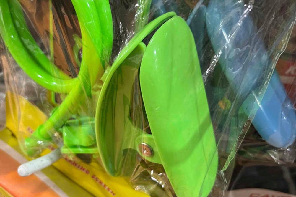 Tablet-Halterung getestet: Verpackung hängt in einem Regal mit grüner Tablet-Halterung zu sehen.