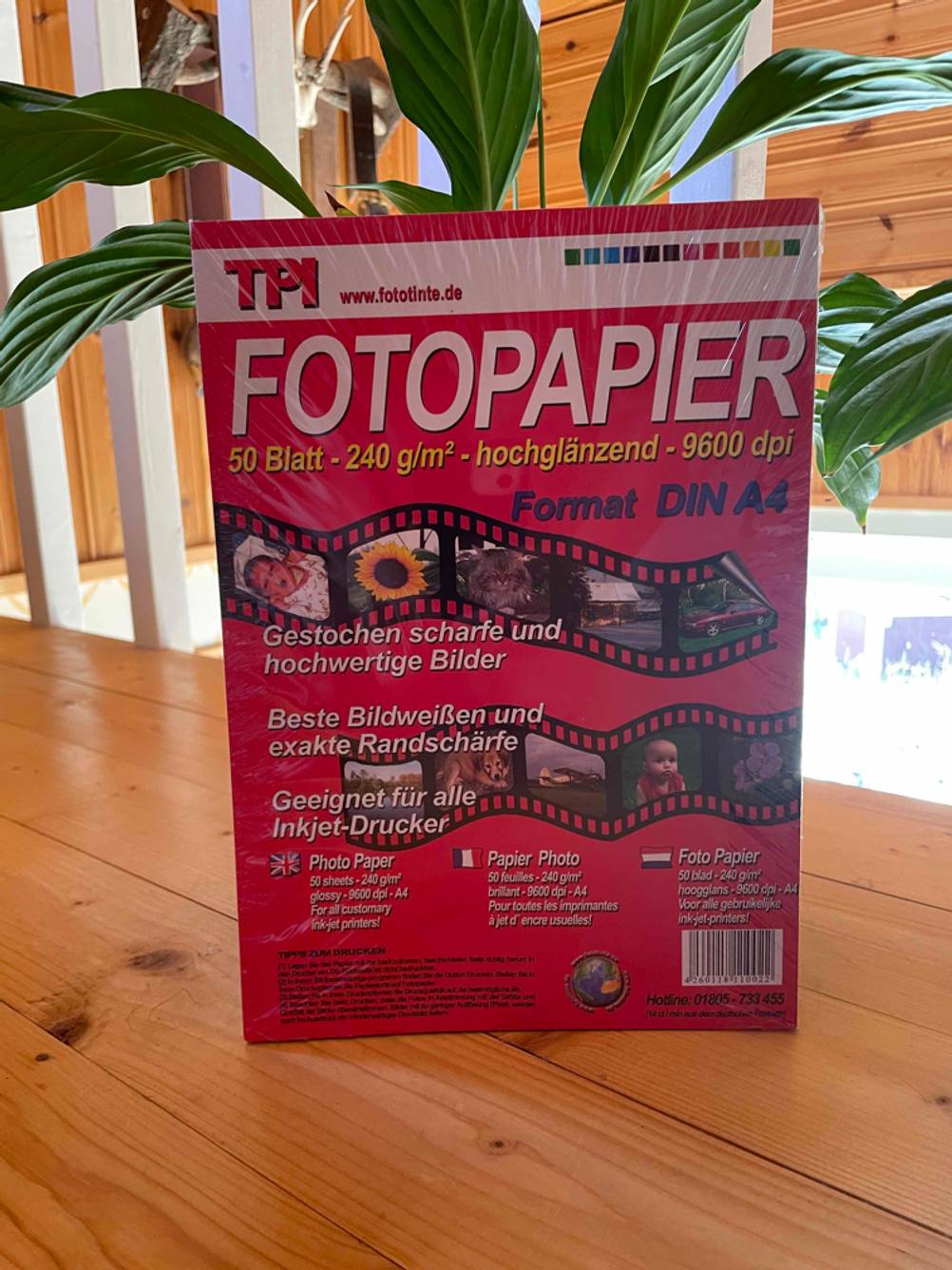 Fotopapier getestet: Auf einem Holzboden vor einer Pflanze steht eine Packung Fotopapier.
