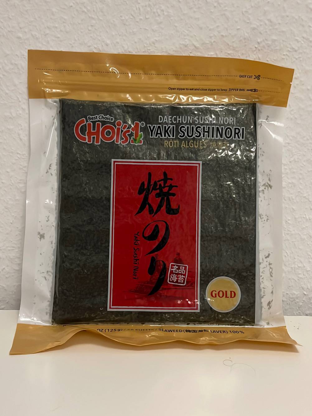 Eine Packung getesteter Nori-Blätter von vorne vor einer hellen Wand.