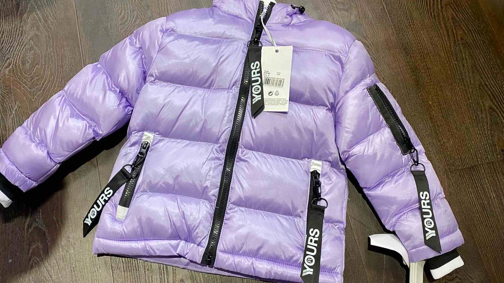 Eine getestete Kinder-Winterjacken für Mädchen von oben auf einer dunklen Fläche.