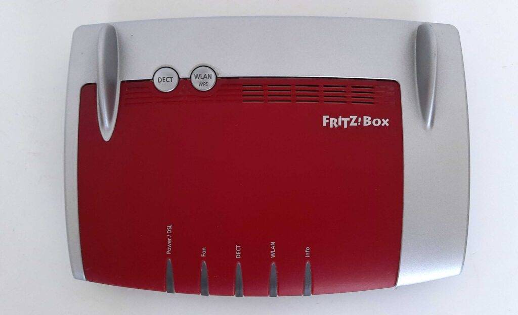 Ansicht von oben auf eine getestete Fritzbox in Rot, Silber vor weißem Hintergrund.