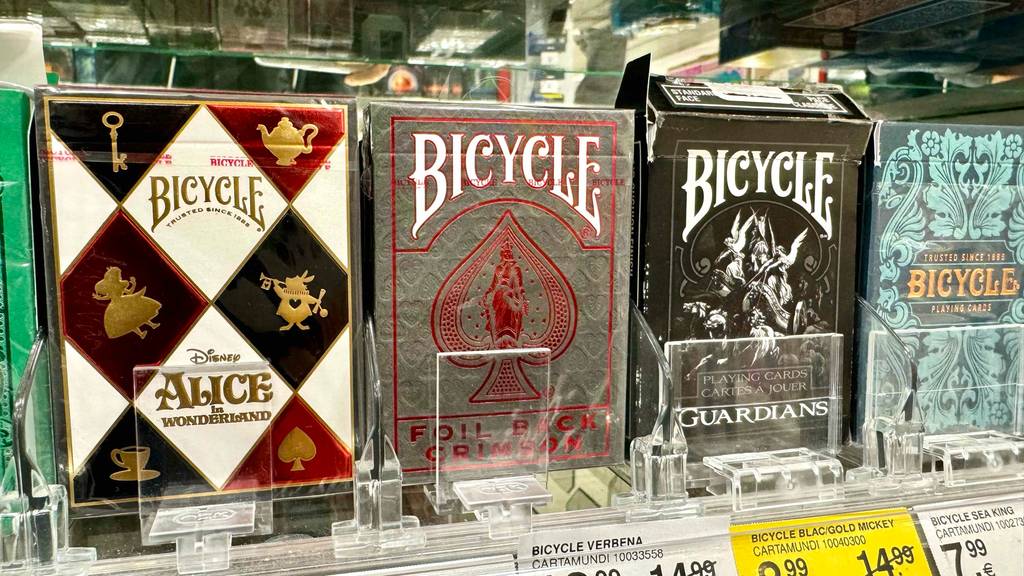 Test: mehrere Packungen Pokerkarten sind in einem Regal aufgereiht.