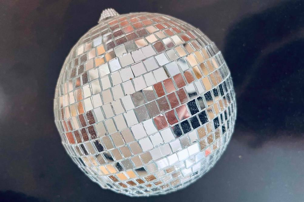 Auf einer dunklen Fläche liegt eine getestete Discokugel für Kinder.