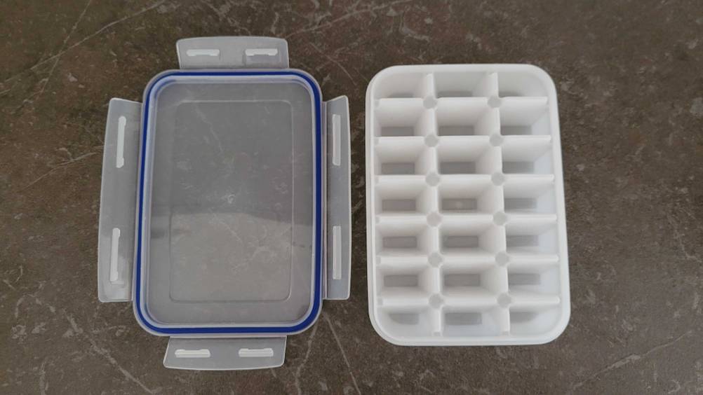 Im Test: Eine Eiswürfelform und ihr Deckel nebeneinander auf einer dunklen Oberfläche.