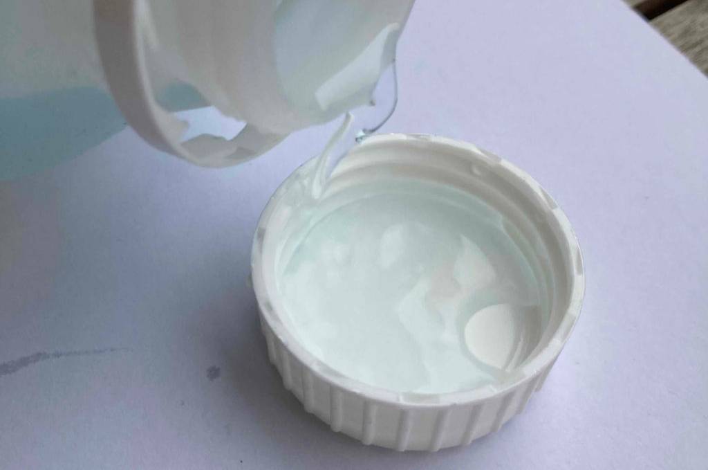 Im Test: Nebelfluid wird von einer Flasche in die Kappe geschüttet.