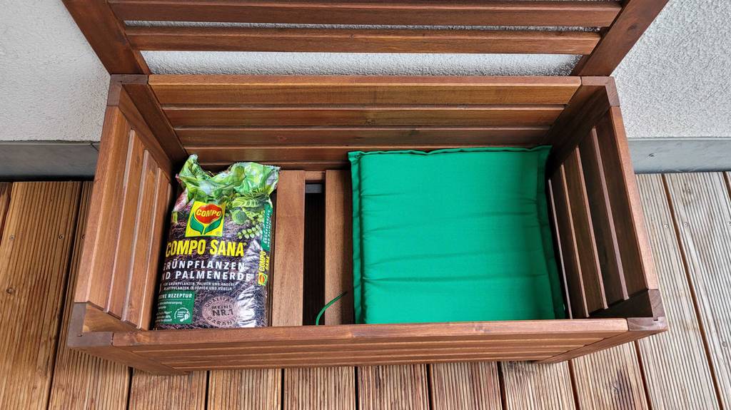 Gartenbank aus Holz mit Inhalt im Stauraum