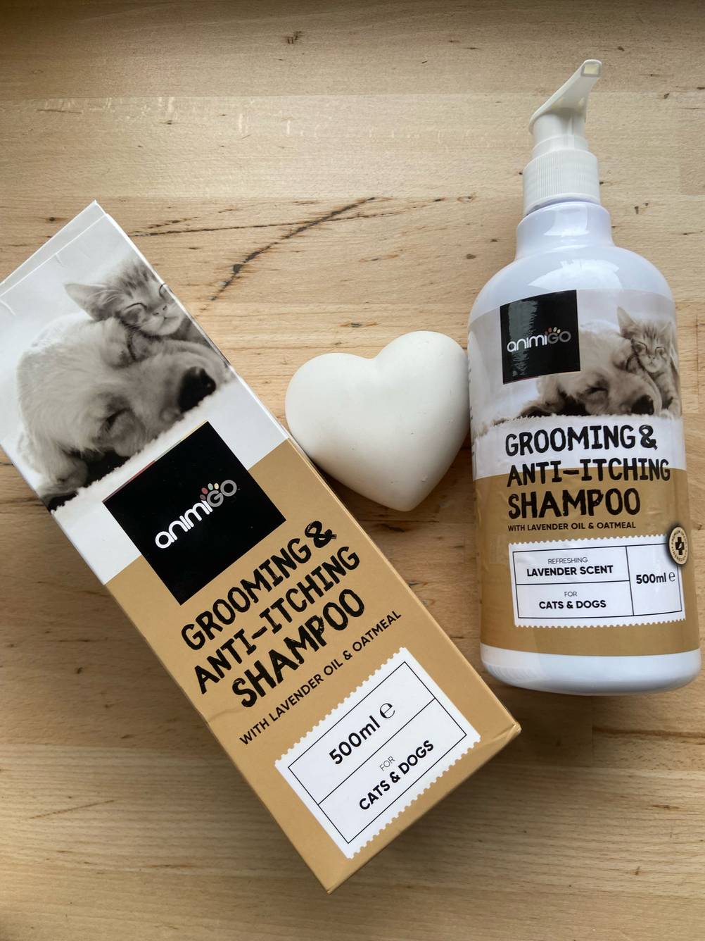 Die Verpackung und das dazugehörige getestete Milben-Shampoo für den Hund liegen neben einem Dekoherz.