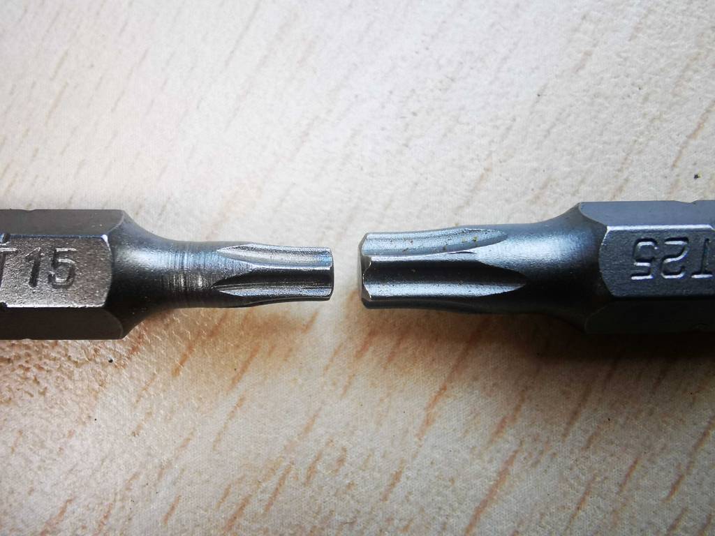 Zwei getestete Torx-Bits in verschiedenen Ausführungen liegen sich auf einer weißen Oberfläche gegenüber.