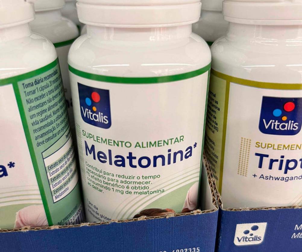 Melatonin getestet: mehrere Dosen Melatonin-Kapseln und eine in Nahaufnahme in einer Schachtel in einem Regal stehend.