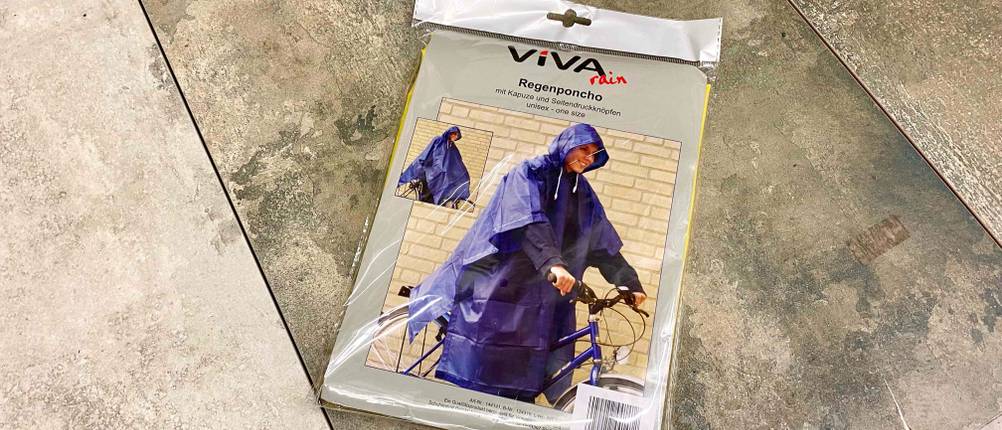 Regenponcho getestet: Vorderseite der Verpackung eines Regenponchos der Marke Viva auf einem Boden platziert.
