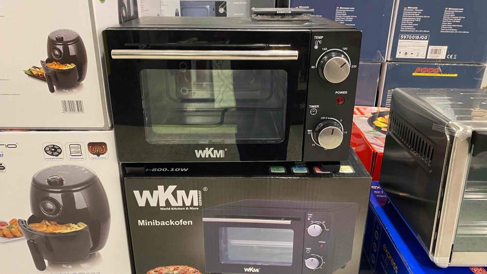 Ein getesteter Minibackofen auf seinem Originalkarton in einer Ausstellungsfläche.