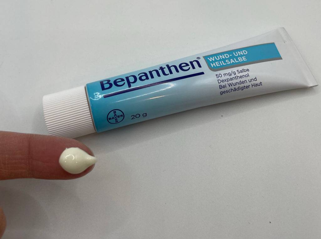 Wund- und Heilsalbe-Test: eine Tube Wund- und Heilsalbe mit einem Klecks Creme auf der Fingerkuppe.