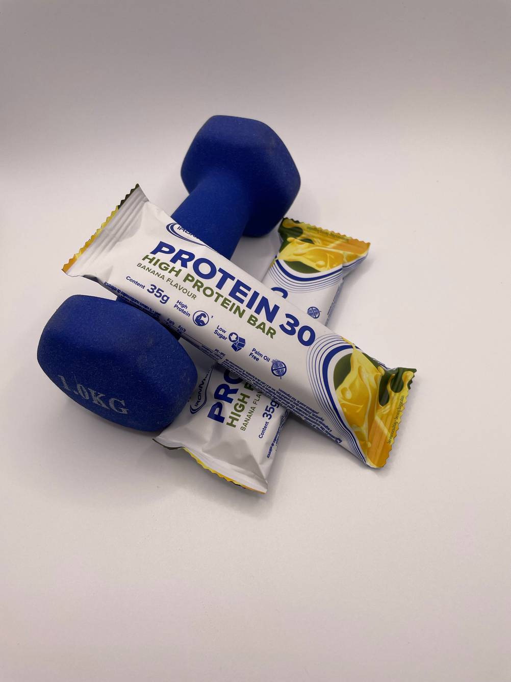 Proteinriegen und Kurzhantel zu sehen.