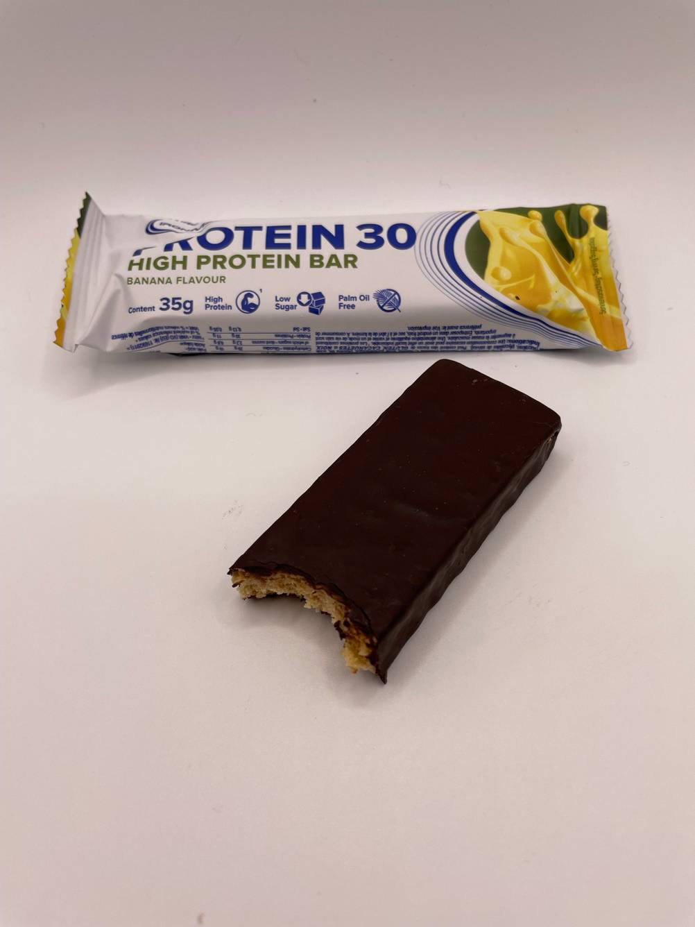 Angebissener Proteinriegel und ein verpackter.