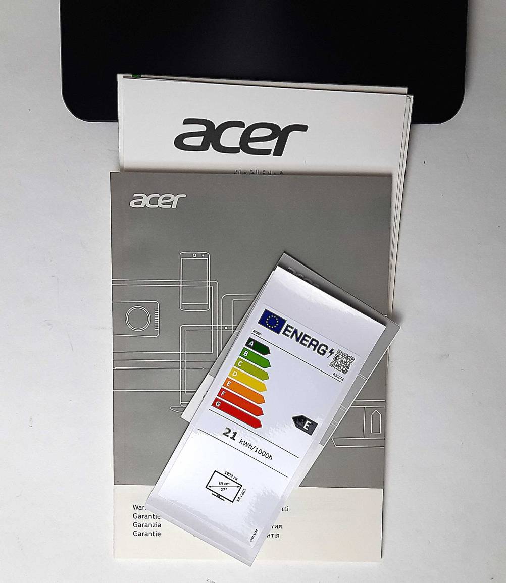 Die Bedienungsanleitungen des getesteten Acer-Monitorsmit 27 Zoll liegen auf einem weißen Tisch.