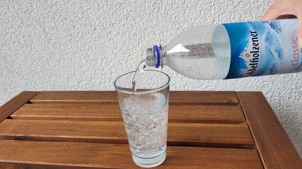 In ein Glas wird getestetes Adelholzener-Wasser eingefüllt.