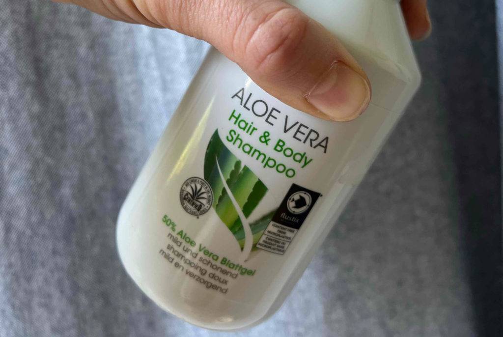 Aloe vera Shampoo in der Hand mit offenem Verschluss.