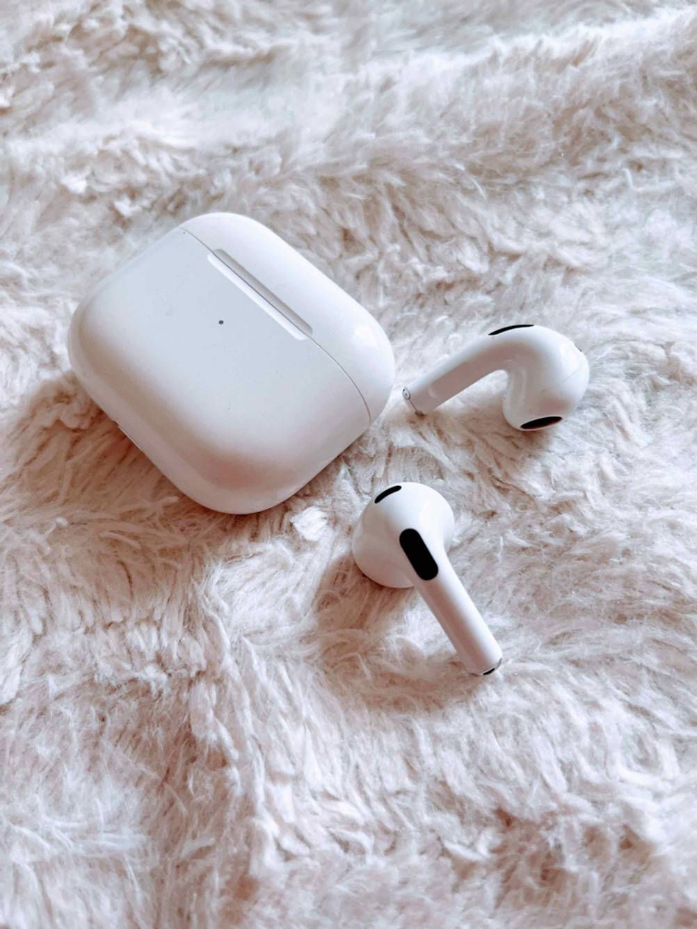 Getestetes In-Ear-Headset auf Plüschdecke mit In-Ear-Kopfhörern.