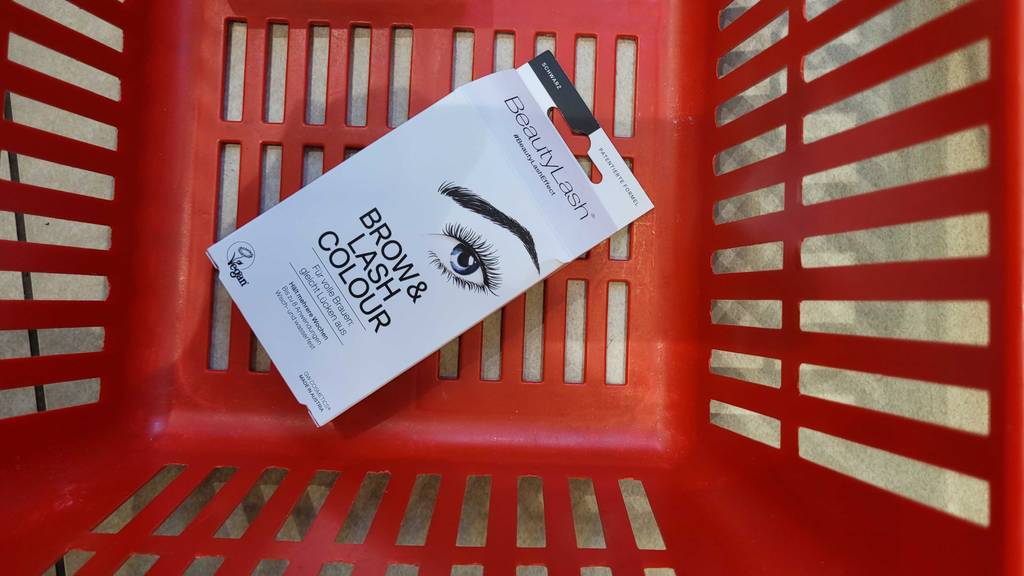 Die getestete vegane Wimpernfarbe liegt in einem roten Korb.