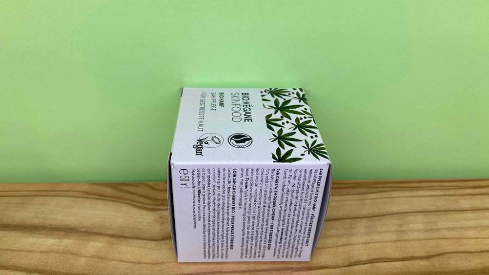 Im Test: Verpackung der Hanfcreme von der Seite vor einer grünen Wand.