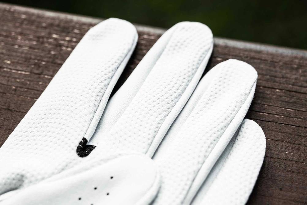 Golfhandschuh-Test: Fingerkuppen von weißem Golfhandschuh in Nahaufnahme.