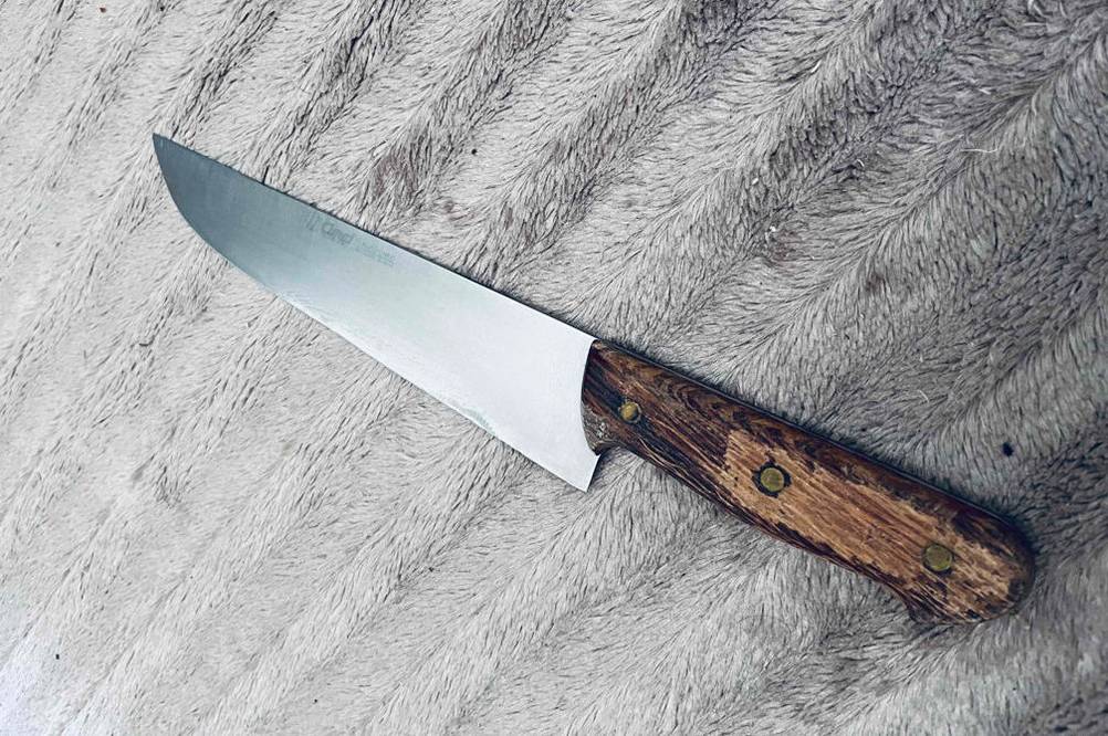 Fleischmesser-Test: Fleischmesser mit Holzgriff liegt auf einem grauen Stoff.