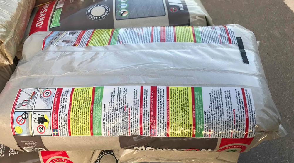 Auf einem Stapel liegt ein getester Pflasterfugenmörtel mit der Rückseite nach oben