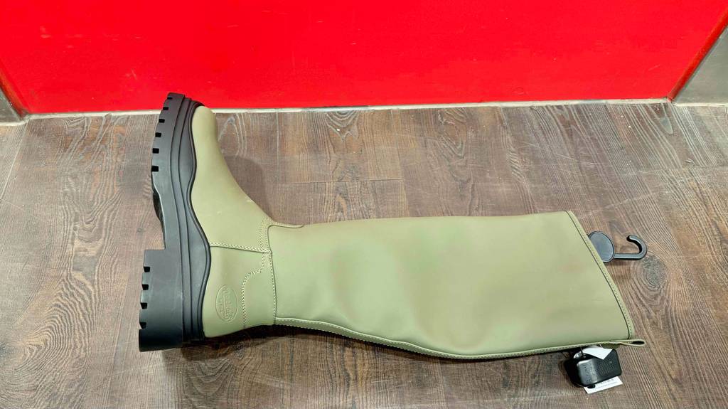 Ein getesteter Winter-Gummistiefel liegt auf einem Boden.