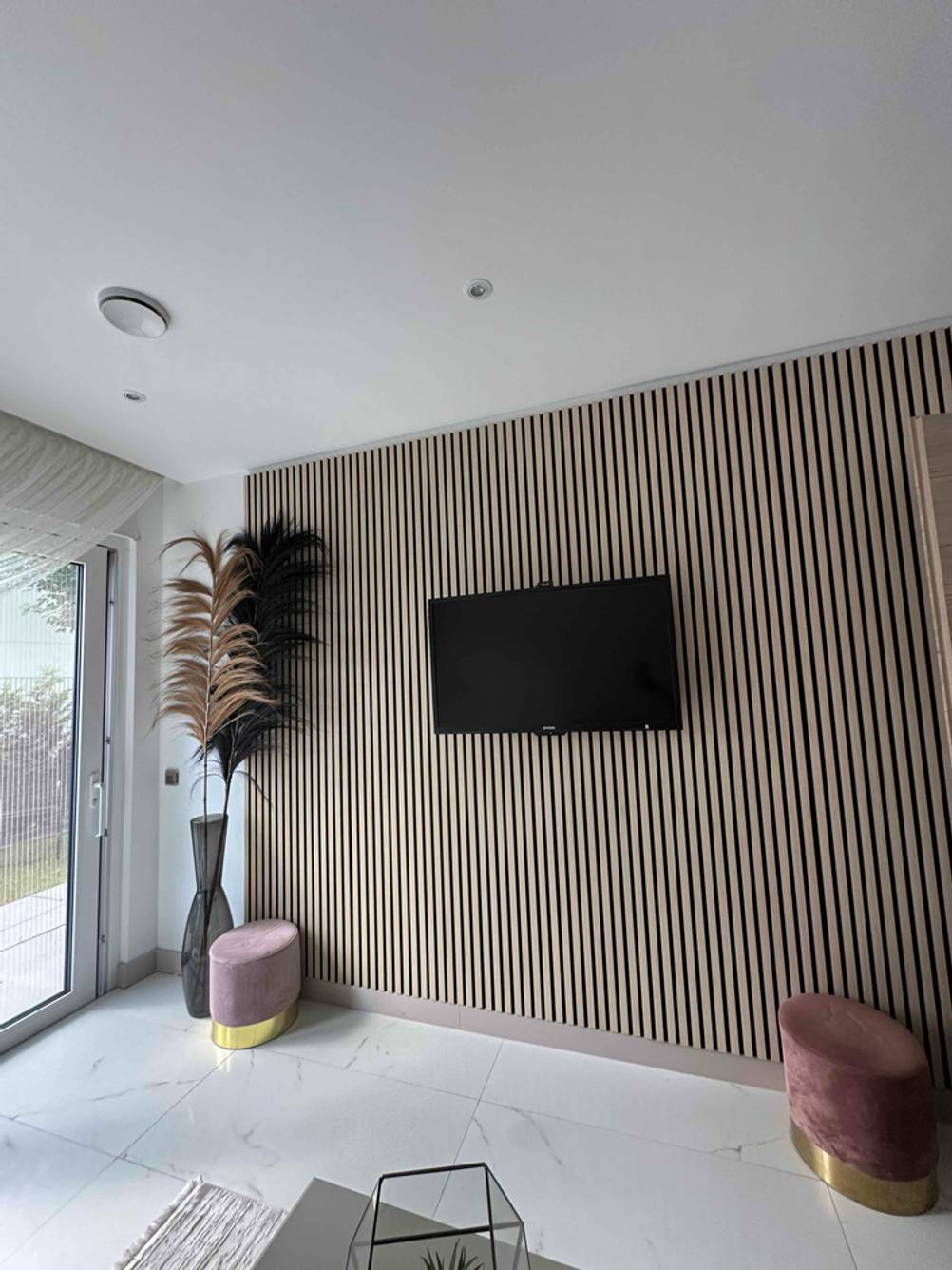 Ein getesteter Dyon-Fernseher hängt in einem Wohnzimmer auf einer Wand.
